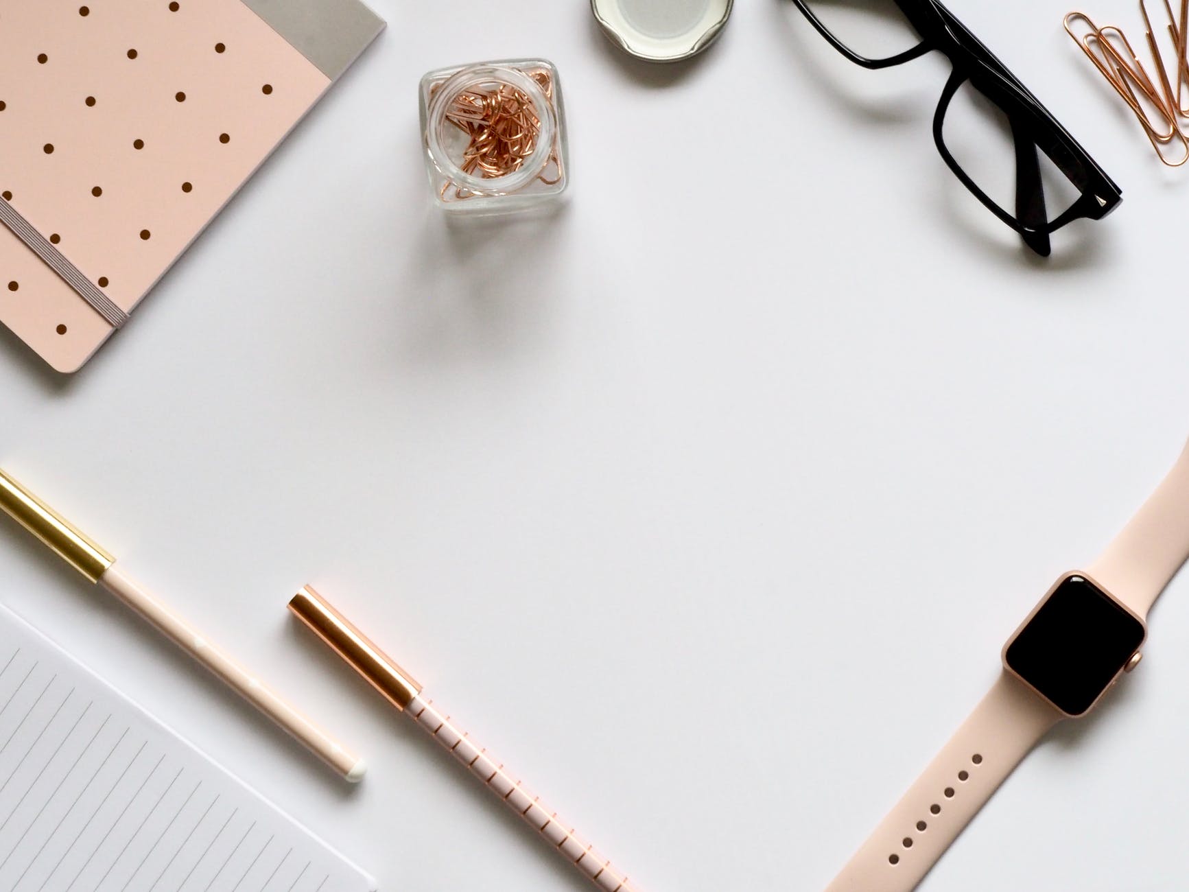 rose gold apple watch with pink sport band near eyeglasses