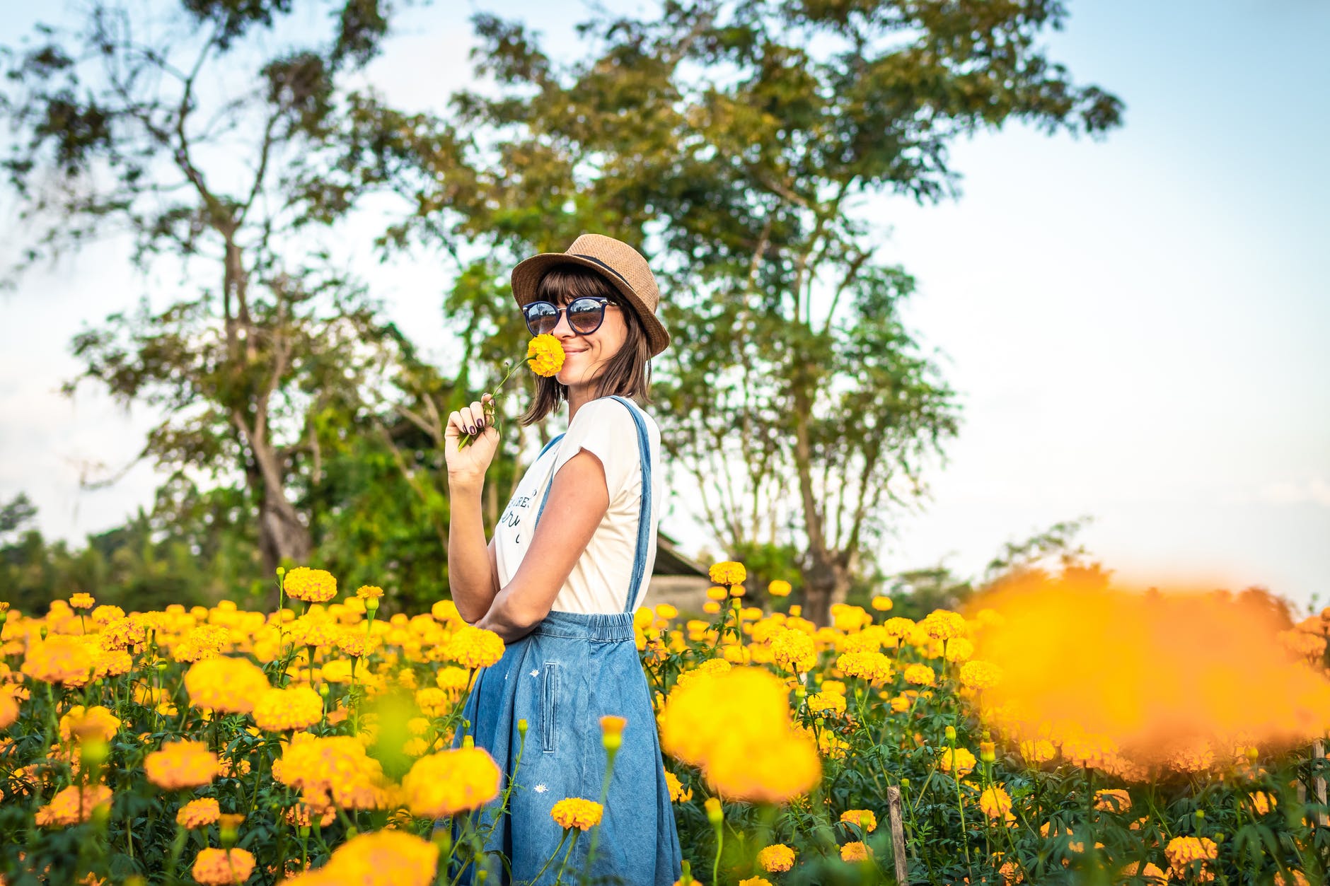 woman sniffing yellow flowers