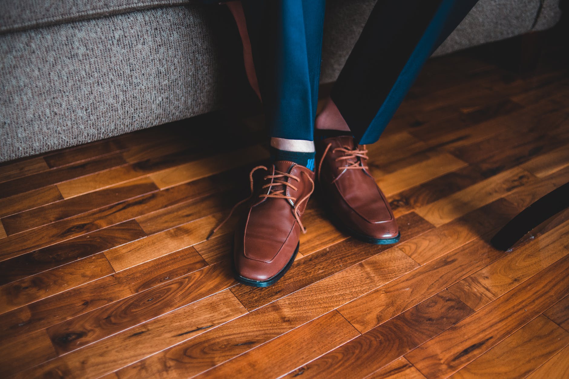 anonymous man in elegant shoes sitting on sofa